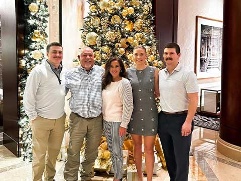 Family photo next to a golden Christmas tree