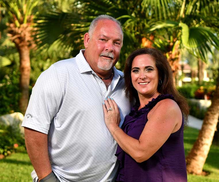 Smiling couple posing for a photo in a park